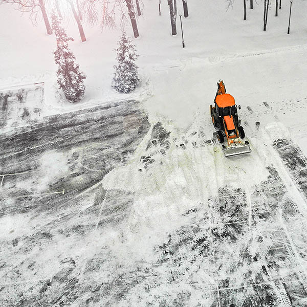 Aerial. Snow remowal tractor cleans street from snow.