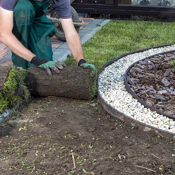 Landscape Gardener Laying Turf For New Lawn