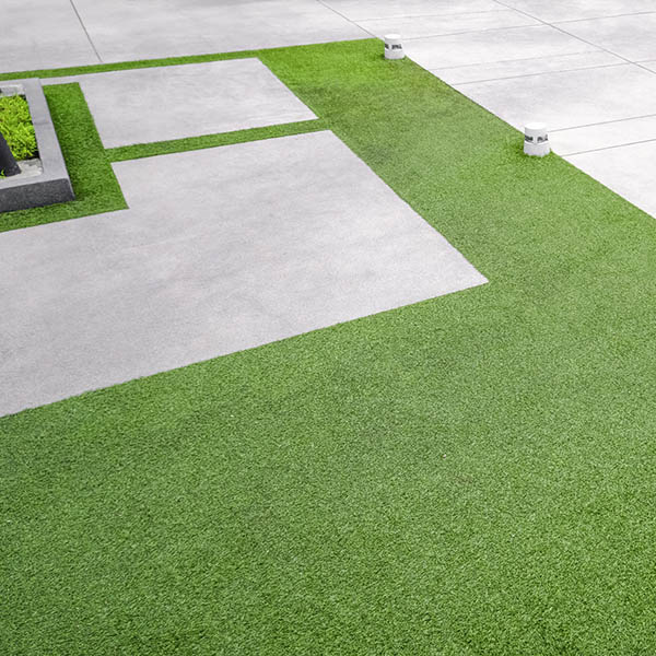 Artificial turf with gravel stone pavement decoration and ornamental plant in Home Gardening area, high angle view with copy space