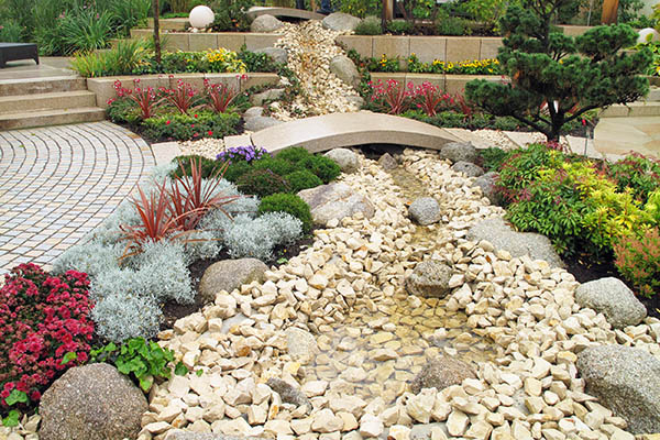 "Garden design. New landscaping with river, bridge and plants"