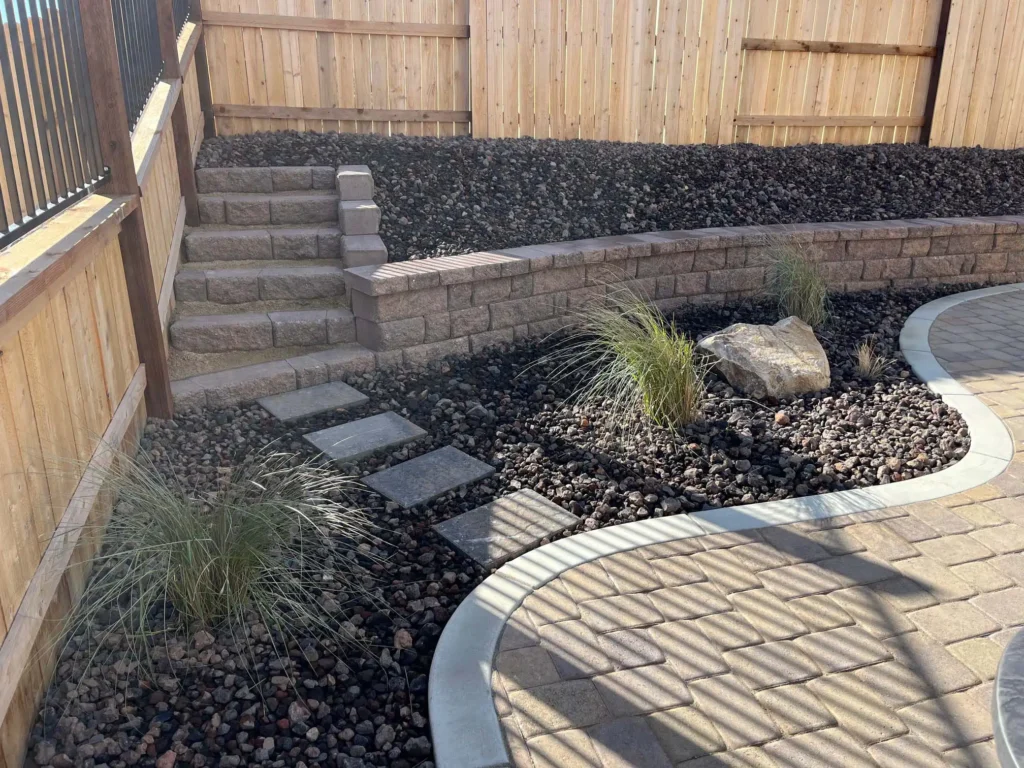 Custom concrete hardscape installation by Legacy Landscaping featuring decorative concrete pavers, retaining walls, landscape steps, and integrated landscape design for a residential backyard.